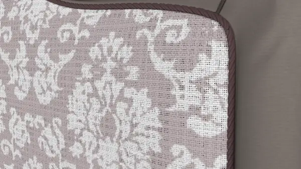 Close-up of a woven damask upholstery fabric with piping along the edge